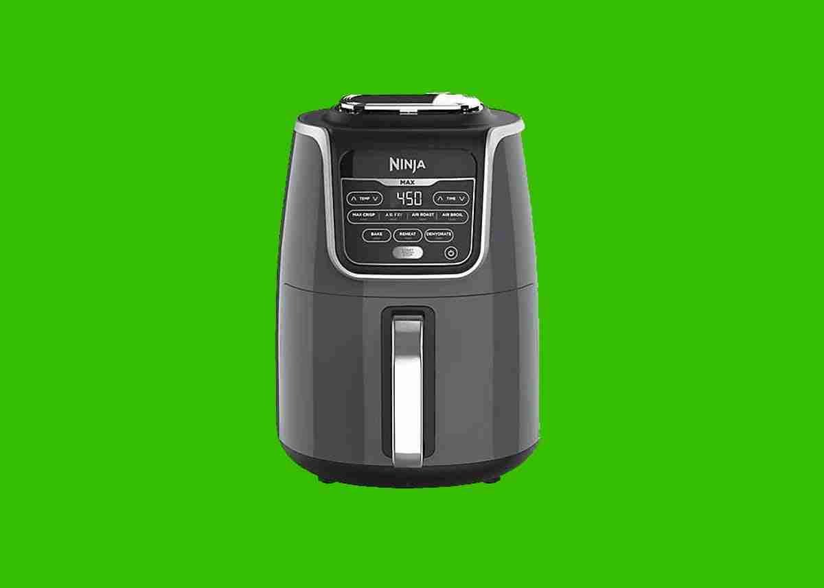 Modern black ninja air fryers on a green background.